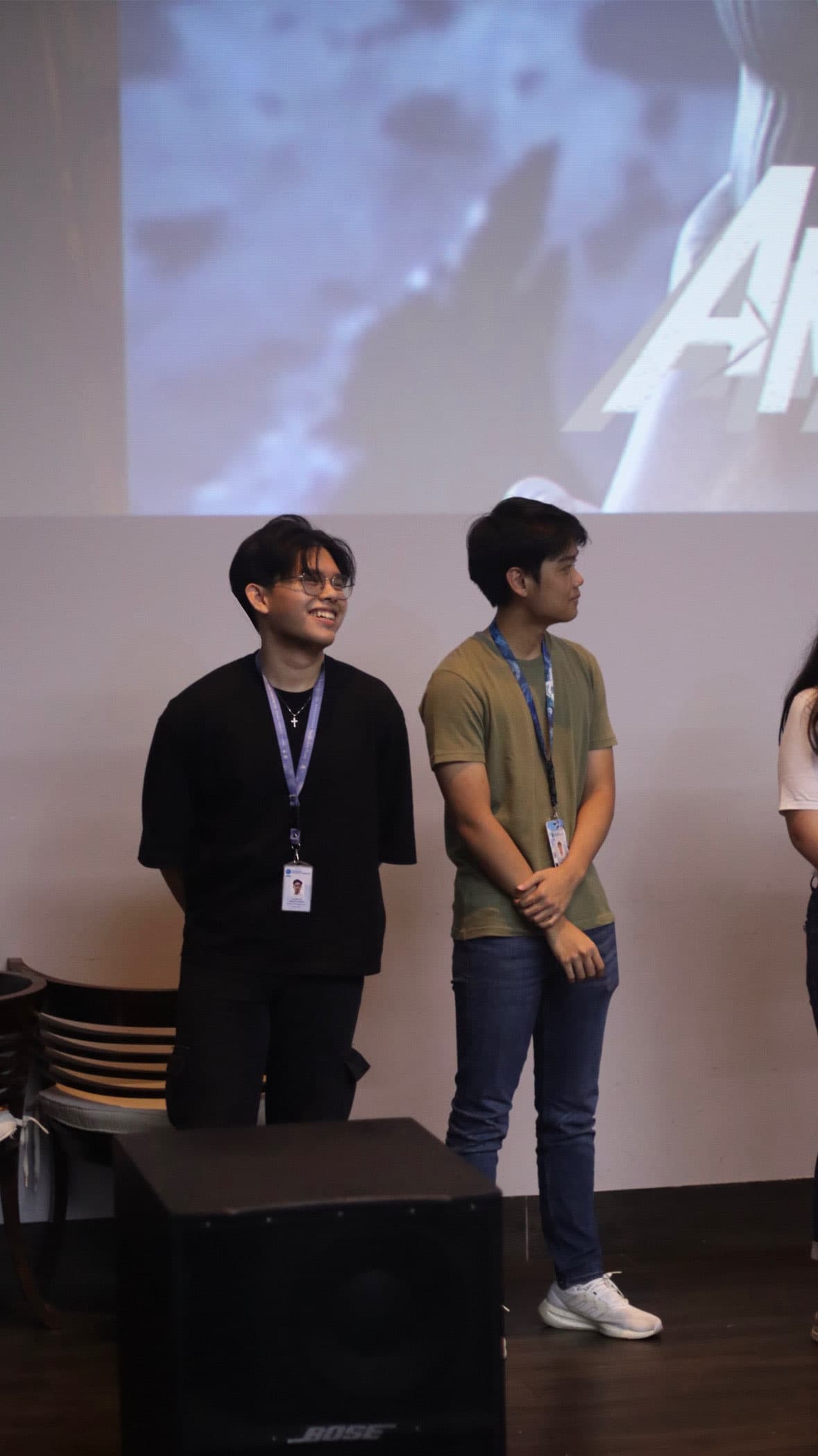 Two speakers presenting on stage with an event background